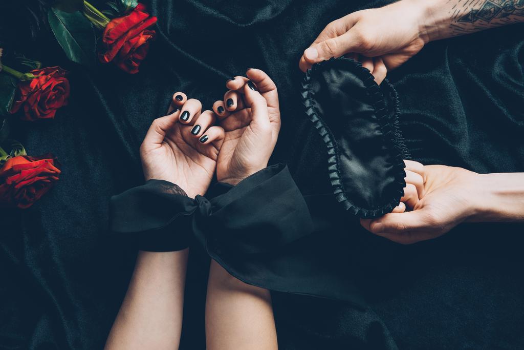 atış bağlı eller ve siyah maske tutan adam kadının kırpılmış - Fotoğraf, Görsel