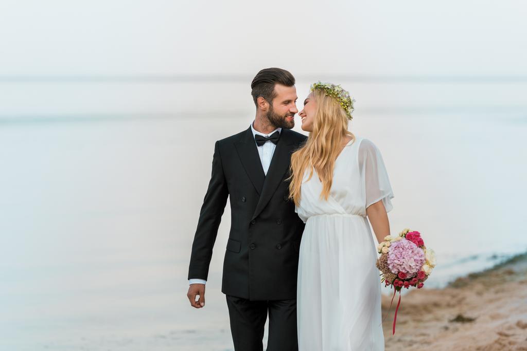 szerető esküvői pár fog csókolni a strandon - Fotó, kép