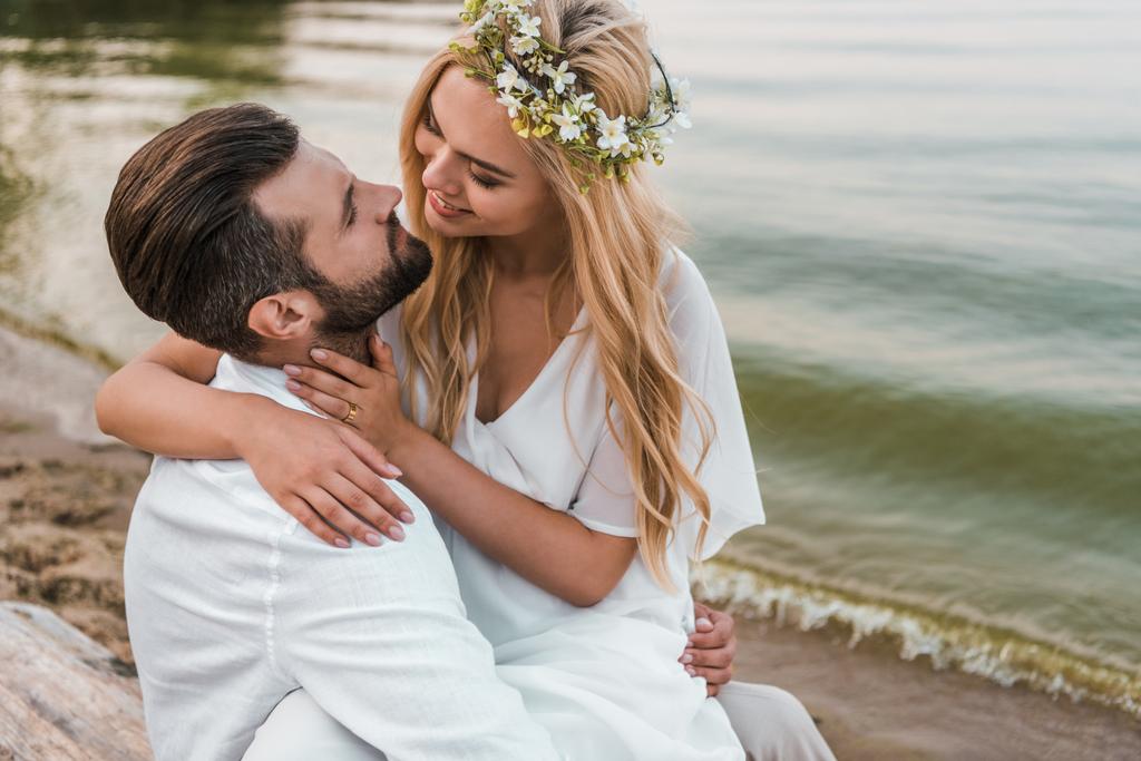 sorridente elegante sposa e sposo andando a baciare sulla spiaggia
 - Foto, immagini