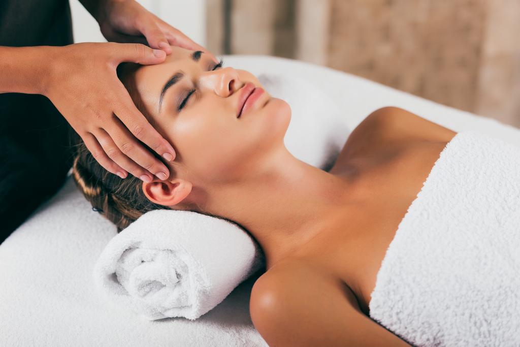 attraente donna rilassante e con massaggio viso nel centro benessere
 - Foto, immagini