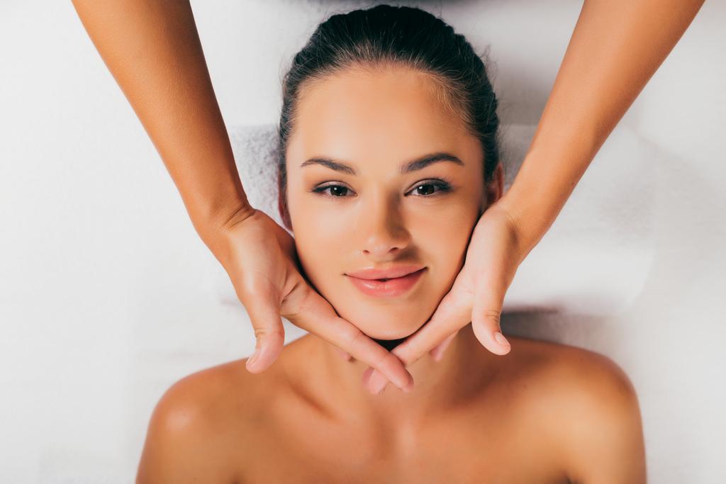 atractiva mujer relajante y tener masaje facial en el centro de masajes
  - Foto, Imagen