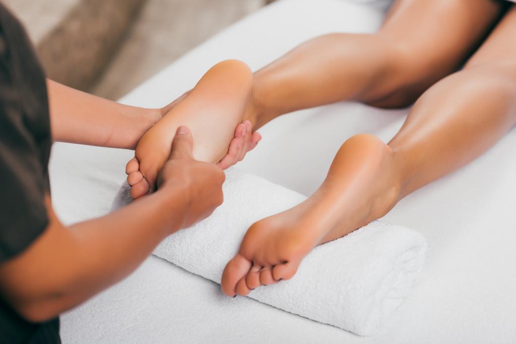 обрезанный вид женщины с массажем ног в спа-салоне
   - Фото, изображение