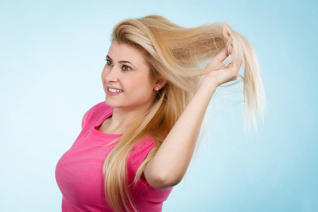 Cuidado del cabello, concepto de ideas de peinado. Mujer cepillándose el pelo largo y rubio con peine
 - Foto, Imagen