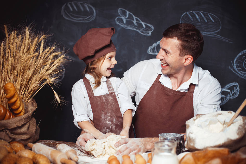 Rindo homem com filha fazendo pão
 - Foto, Imagem