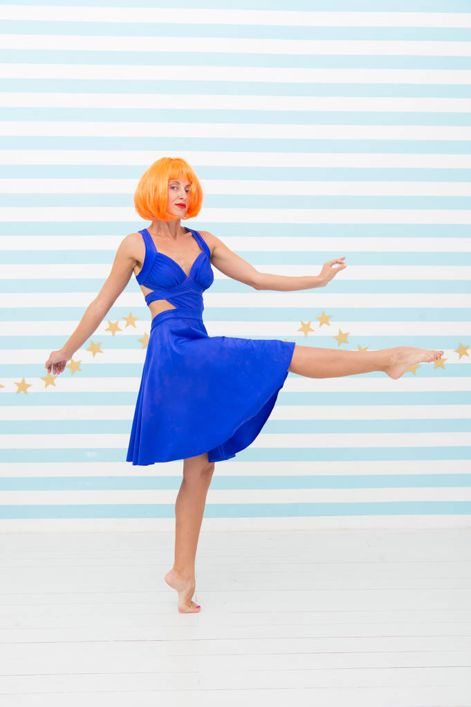 Sorglosigkeit Mädchen mit verrücktem Blick macht Schritt. So viel Spaß. Verrücktes Mädchen mit orangefarbenen Haaren, das barfuß tanzt. Völlig unbeschwert. Schönheits- und Sommermode-Konzept - Foto, Bild