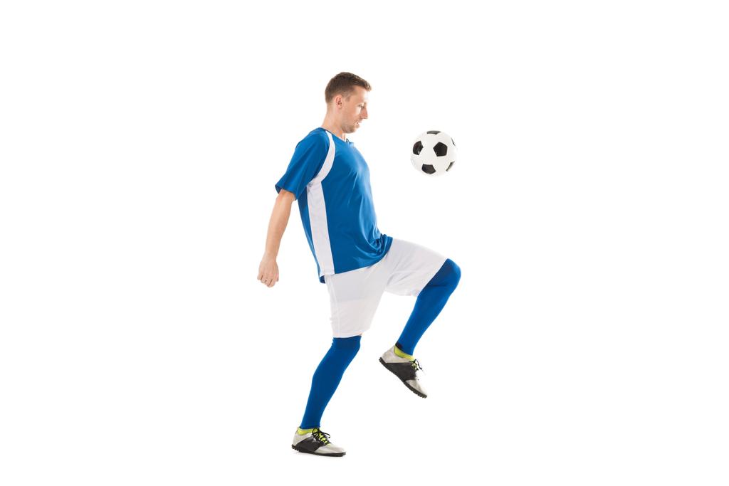 вид сбоку на тренировку юного футболиста с мячом, изолированным на белом
 - Фото, изображение