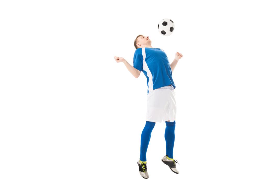 Widok pełnej długości młody piłkarz uderzając piłkę z klatki piersiowej na białym tle - Zdjęcie, obraz