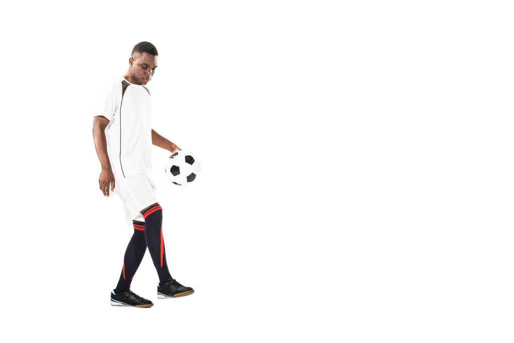 pohledný mladý afroamerické sportovec hraje s fotbalovým míčem izolované na bílém - Fotografie, Obrázek