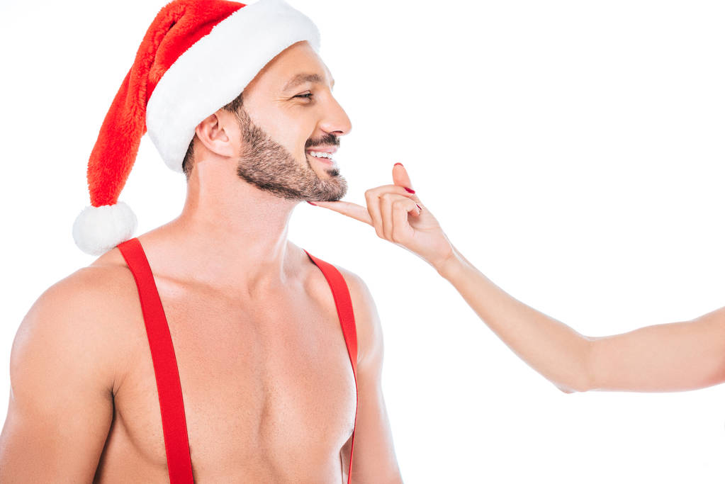 przycięte zdjęcie kobiety dotknięcie brodą z chłopakiem mięśni shirtless w Boże Narodzenie kapelusz na białym tle  - Zdjęcie, obraz