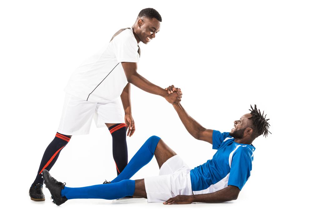 happy young african american sportsman helping soccer player isolated on white - Photo, Image
