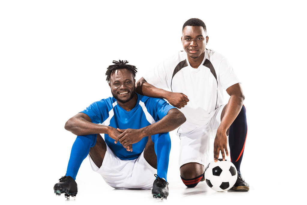 ευτυχισμένος αφρικανική αμερικανική ποδοσφαιριστές που χαμογελά στη φωτογραφική μηχανή που απομονώνονται σε λευκό - Φωτογραφία, εικόνα