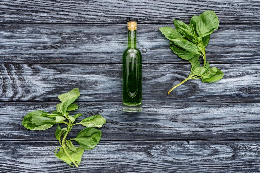 vista superior de la botella con aceite esencial de hierbas naturales y hojas verdes en la mesa de madera
  - Foto, imagen