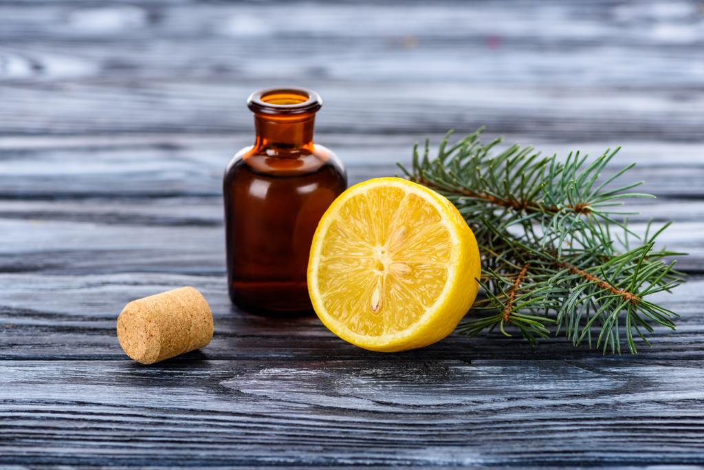 botella de aceite esencial de hierbas naturales, ramas de abeto, limón y corcho en la superficie
 - Foto, Imagen