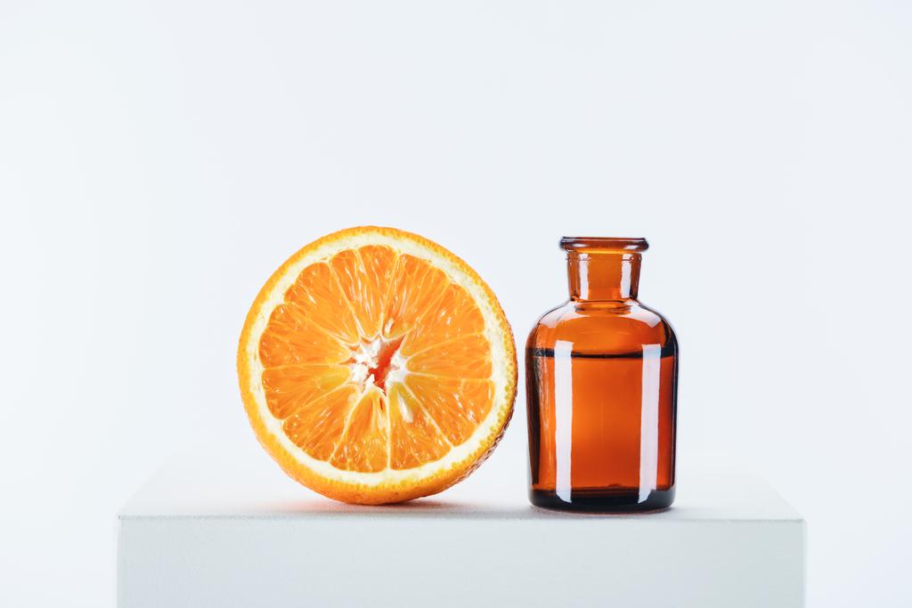 bouteille d'huile essentielle naturelle à base de plantes et d'orange coupée sur cube blanc
 - Photo, image