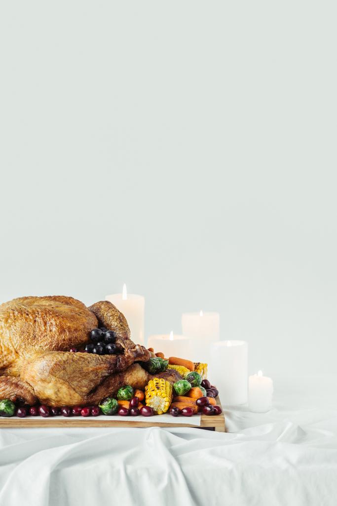 κλείνω πάνω θέα του τοποθετημένα κεριά, γιορτινή γαλοπούλα με ψητά λαχανικά για δείπνο διακοπές σε επιτραπέζια σε γκρίζο φόντο, ημέρα των Ευχαριστιών διακοπών έννοια - Φωτογραφία, εικόνα