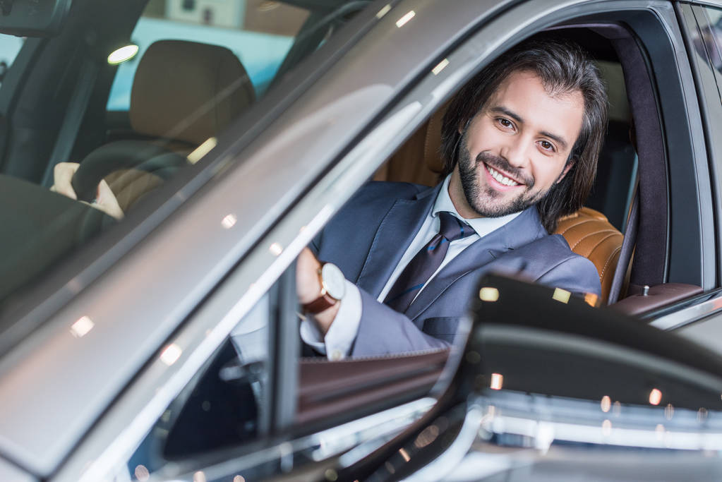 портрет бізнесмена, що сидить у новому автомобілі для тестового водіння в дилерському салоні
 - Фото, зображення