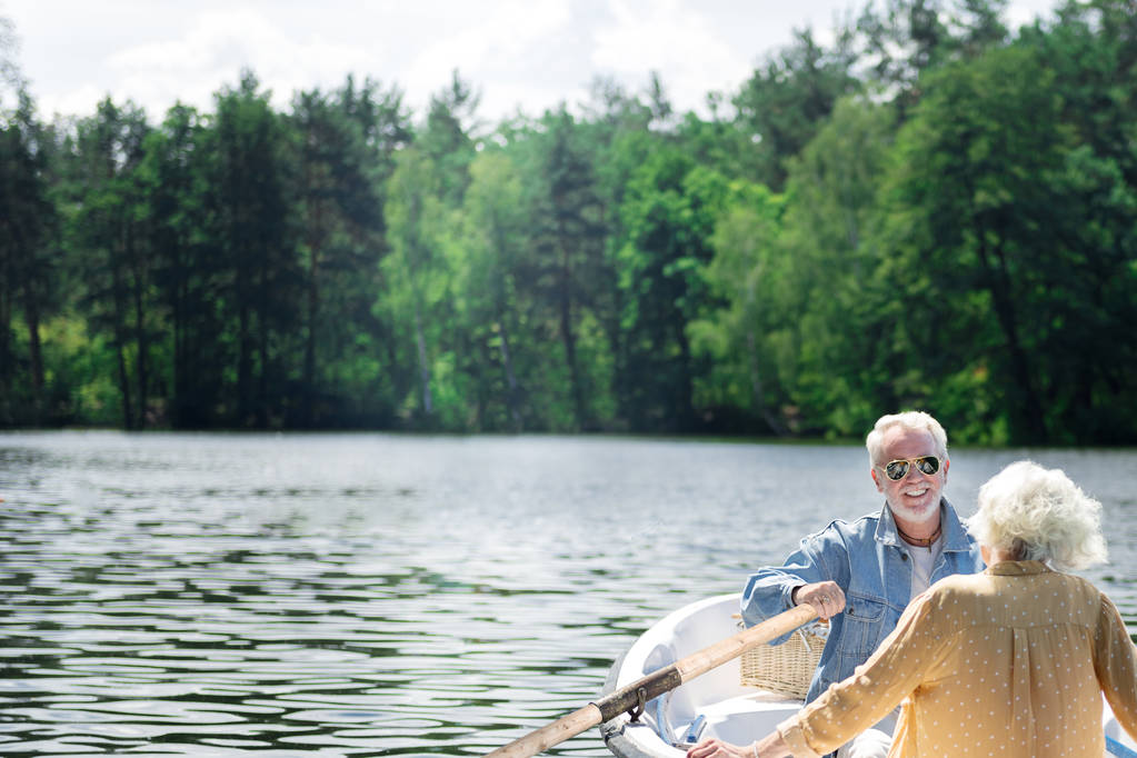 attraktiver Rentner rudert Boot und lächelt glücklich zu seiner Frau - Foto, Bild