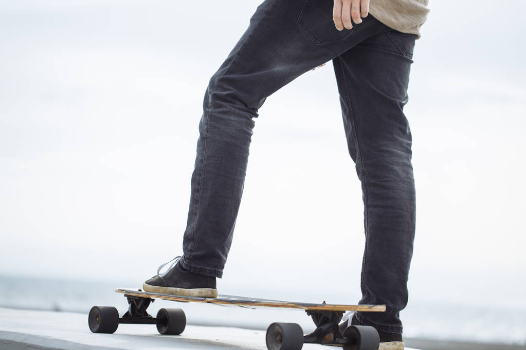 Close up of man foot riding longboard in park - Photo, Image