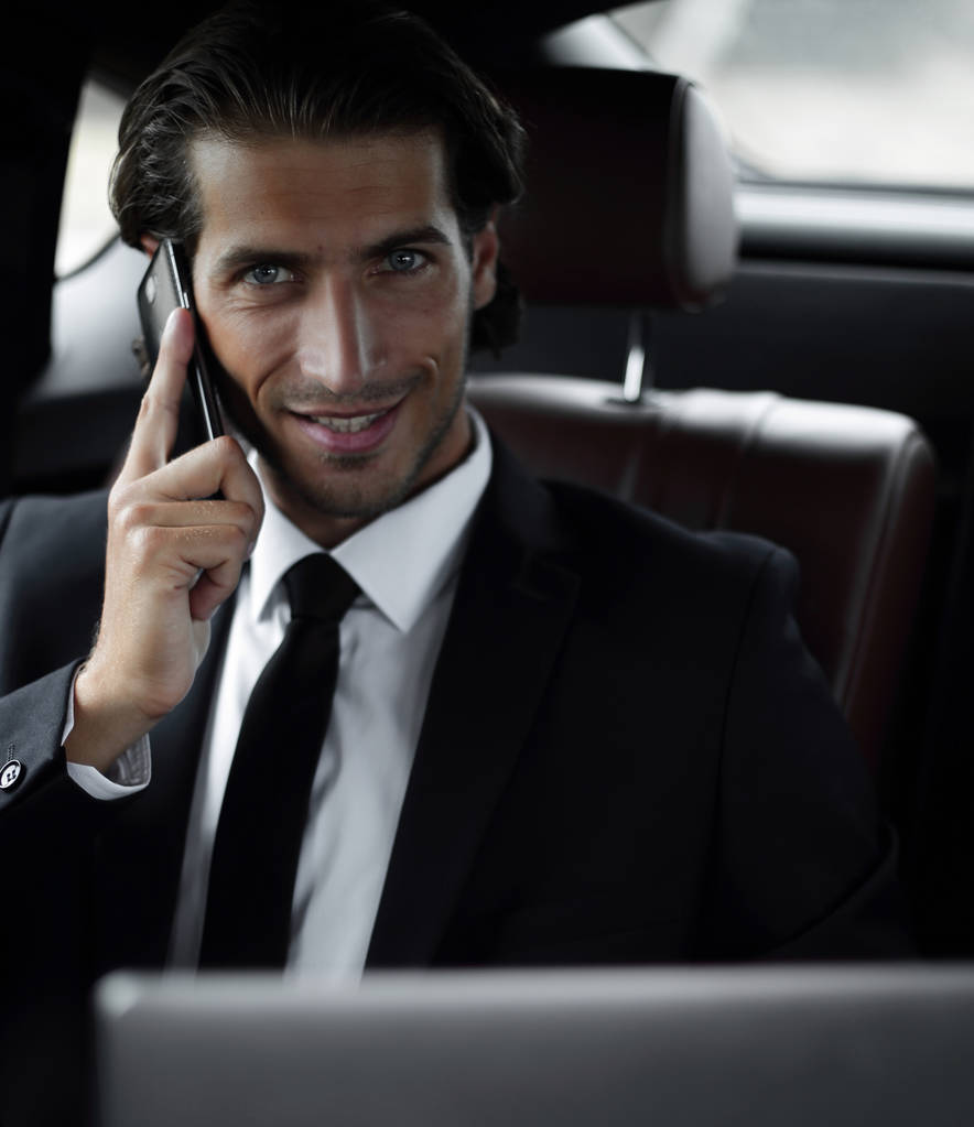 Όμορφος επιχειρηματία χρήση κινητού τηλεφώνου στο αυτοκίνητο. - Φωτογραφία, εικόνα