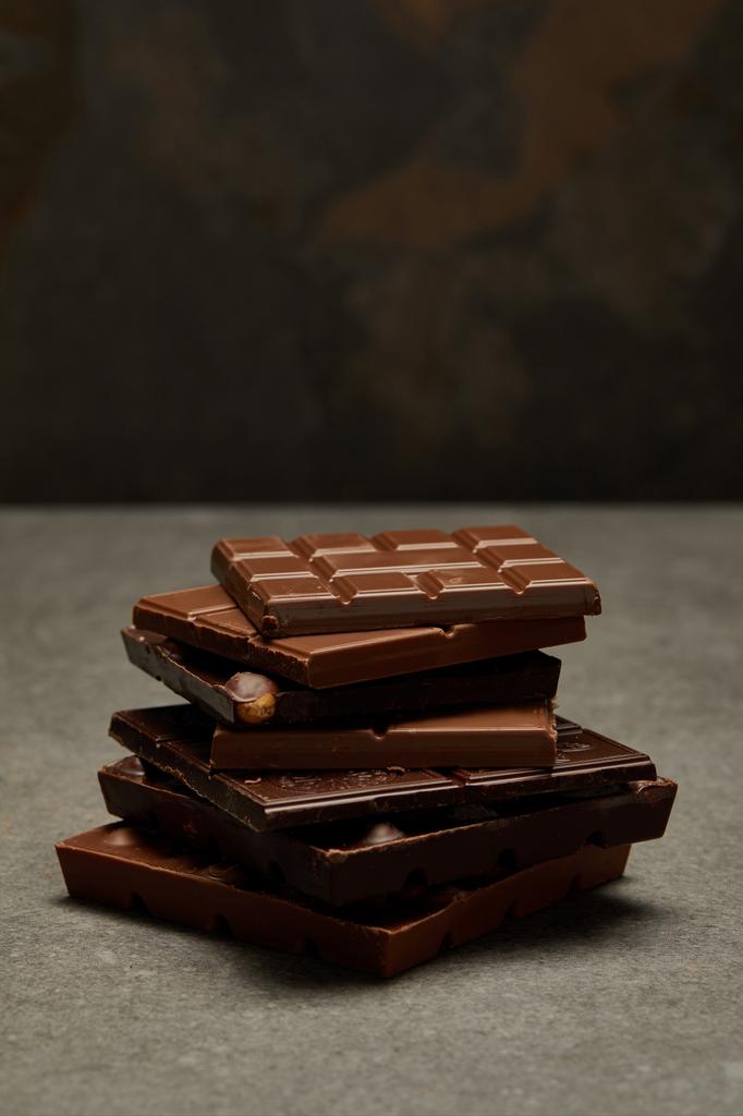 γκρο πλαν θέα γλυκό ανάμικτες σωρευμένων ράβδων σοκολάτας σε γκρι  - Φωτογραφία, εικόνα