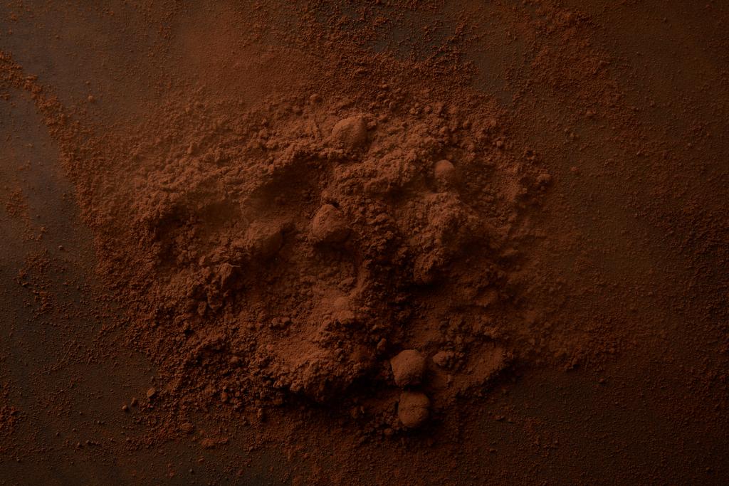 Draufsicht auf köstliches Kakaopulver auf dunklem Hintergrund - Foto, Bild