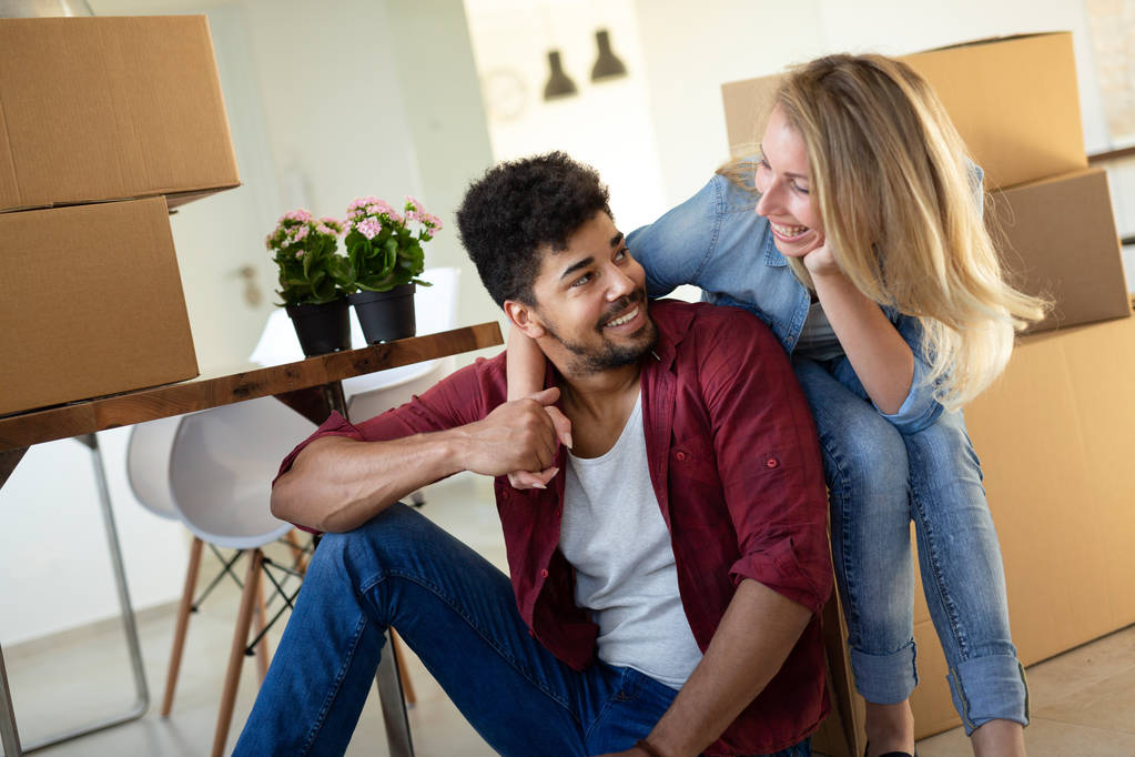 Young couple in love unpacking cardboard boxes at new home moving in concept - Photo, Image