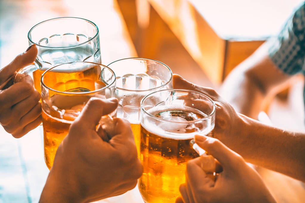 Amigos brindam com copos de cerveja leve no pub
. - Foto, Imagem
