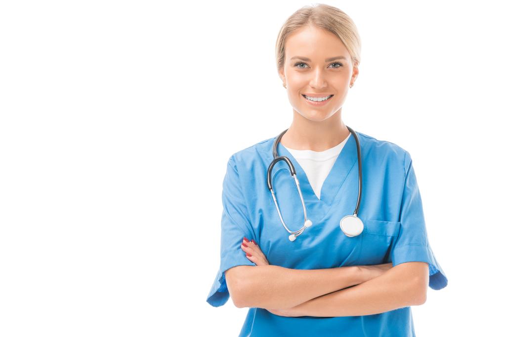 happy young nurse with crossed arms looking at camera isolated on white - Photo, Image