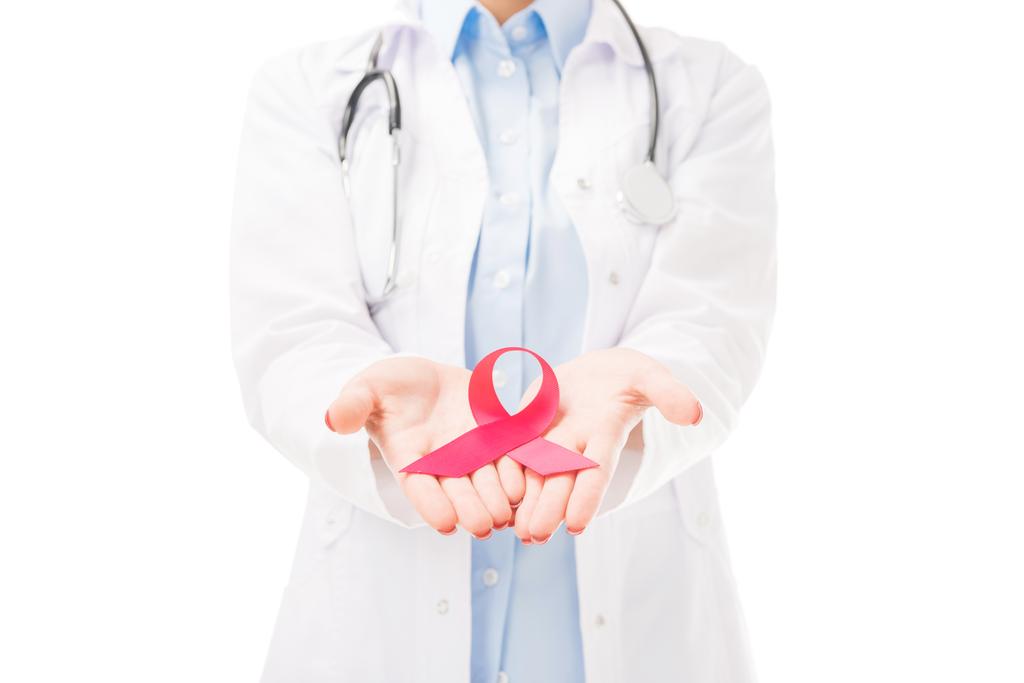 abgeschnittene Aufnahme einer Ärztin im weißen Mantel mit Hilfsmitteln Bewusstsein rotes Band Symbol isoliert auf weiß - Foto, Bild