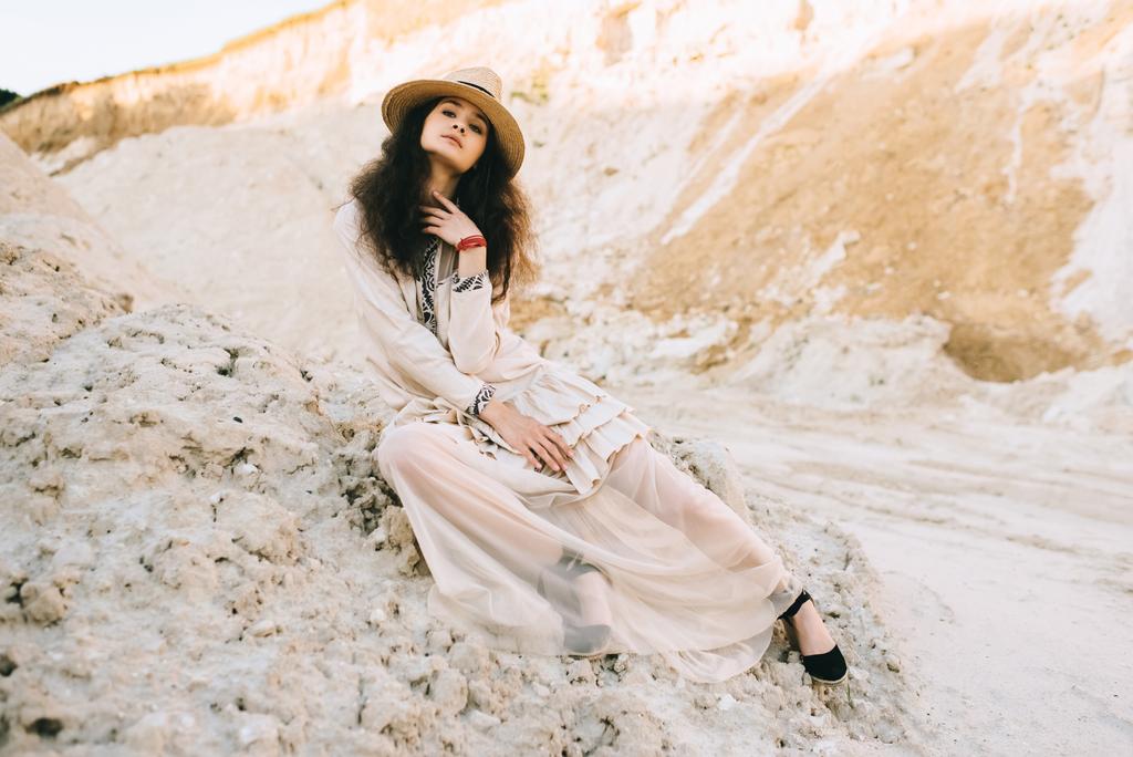 elegant girl posing in trendy dress and straw hat in sandy canyon - Photo, Image