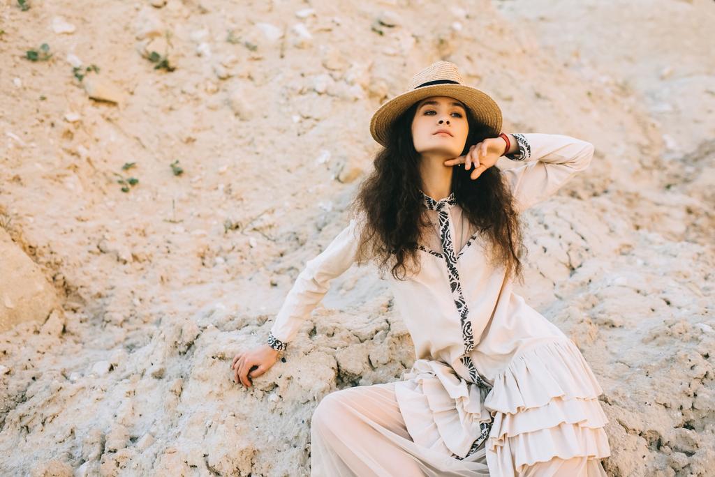 stylowa dziewczyna kręcone pozowanie w słomkowym kapeluszu w piaszczyste Kanion - Zdjęcie, obraz