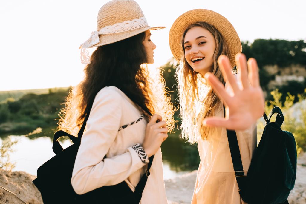 красиві щасливі подружки в солом'яних капелюхах проводять час разом
 - Фото, зображення