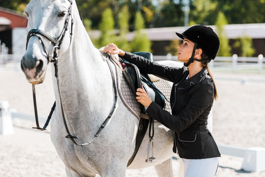 魅力的な女性の馬術の乗馬クラブで乗用馬を修正 - 写真・画像