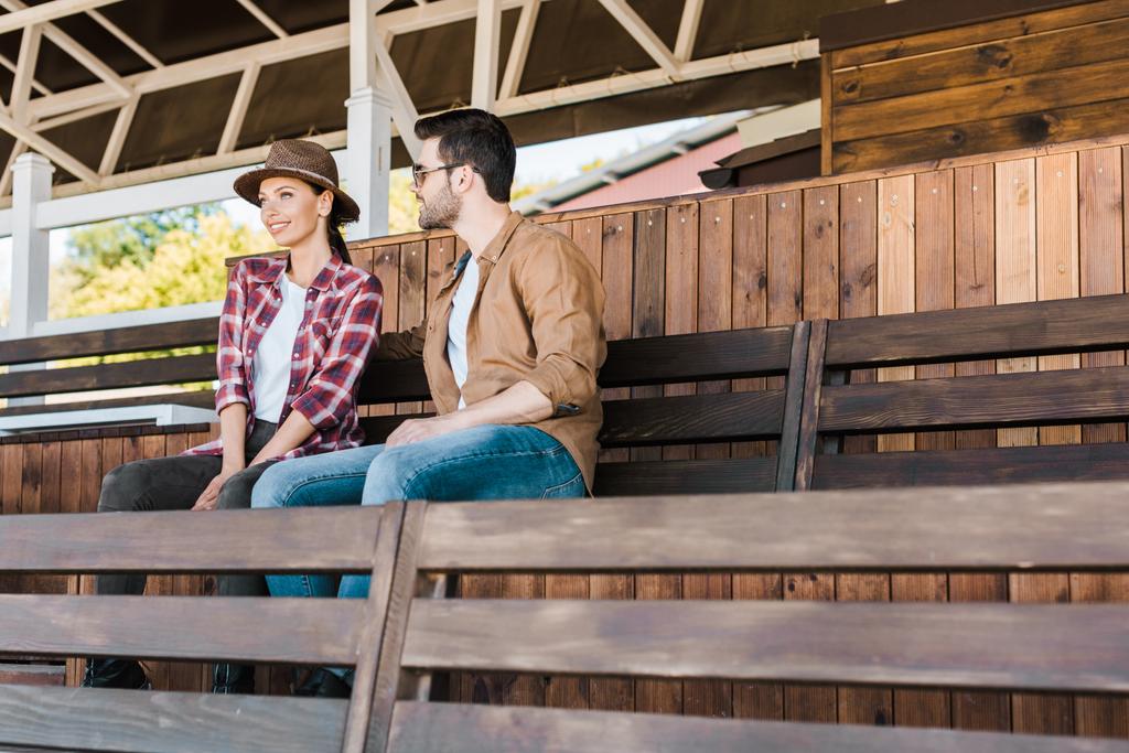 cowboy alegre e vaqueira em roupas casuais sentado no banco no estádio do rancho
 - Foto, Imagem
