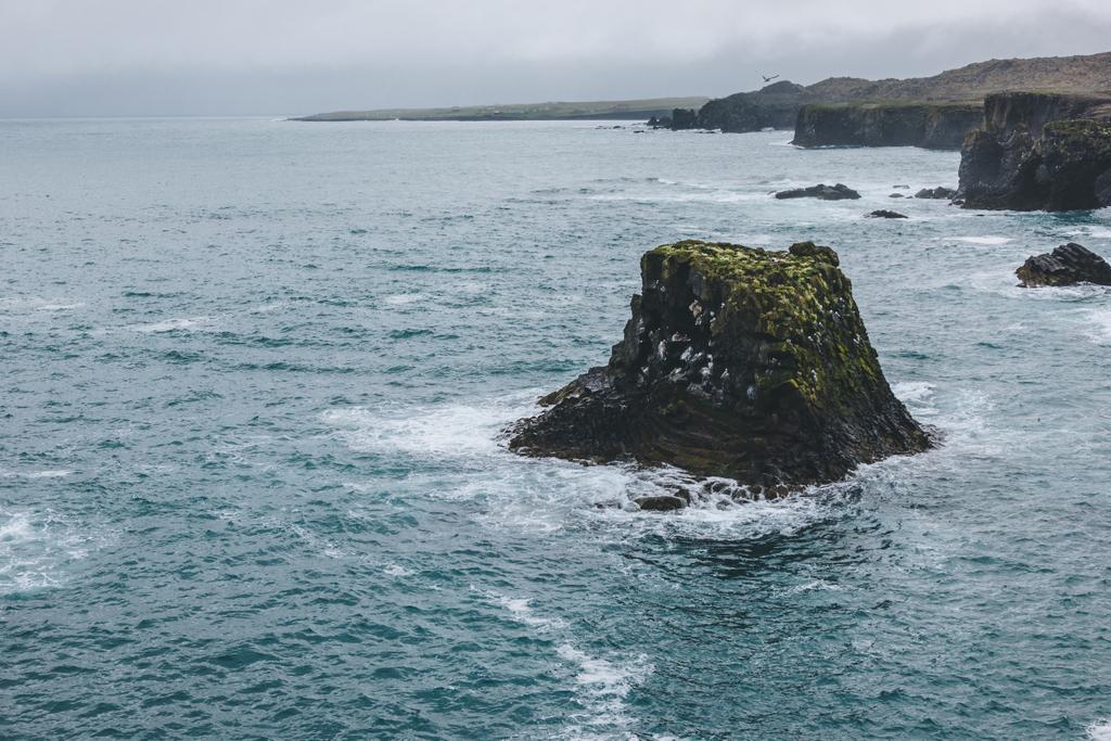 festői lövés a sziklák és a szikla-kék-óceán viharos napon Arnarstapi, Izland - Fotó, kép