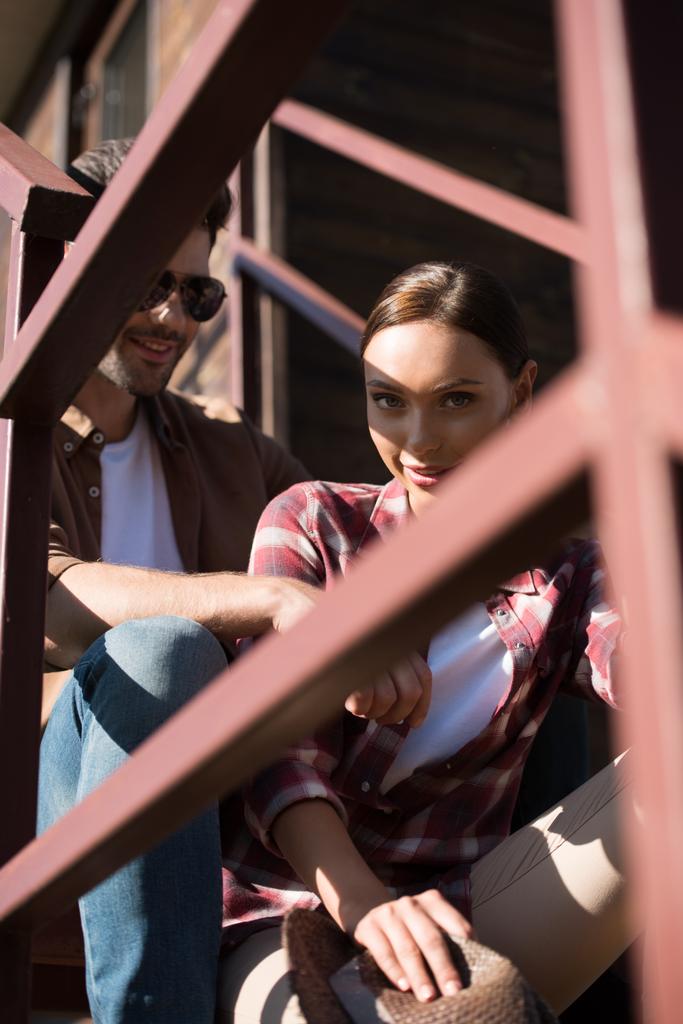 Nézd keresztül kerítésen férfi és a nő ül a lépcsőház Ranch alkalmi ruhák - Fotó, kép