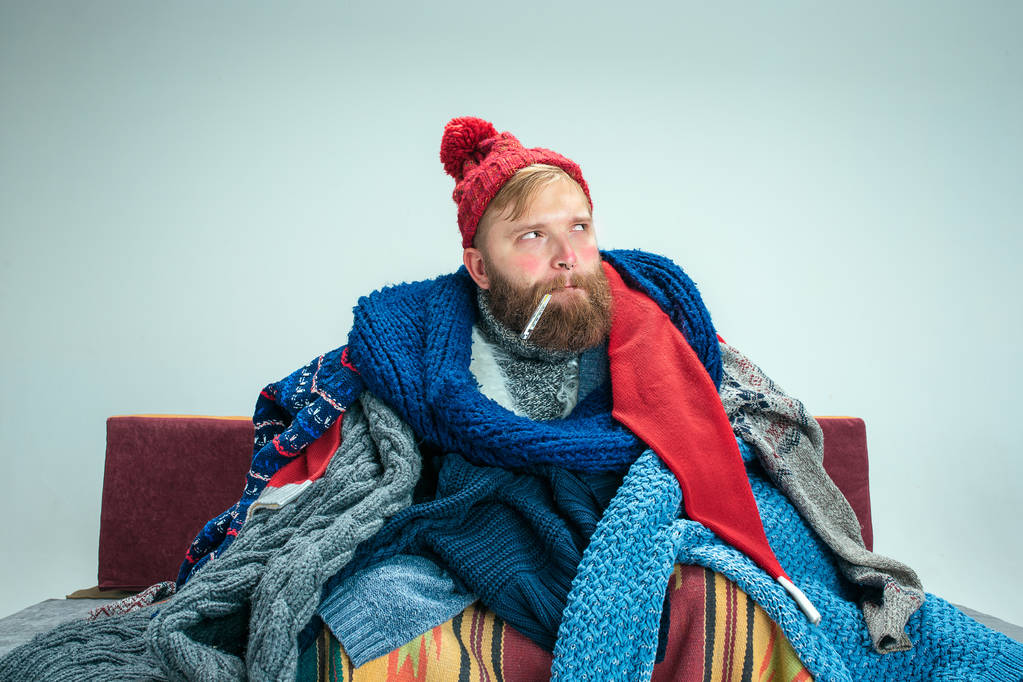 Bearded Man with Flue Sitting on Sofa at Home. Healthcare Concepts. - Photo, Image