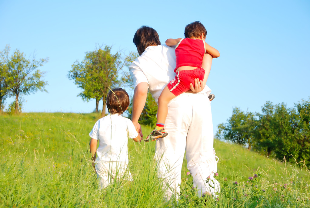 Padre joven en blanco con niños en el hermoso prado
 - Foto, imagen