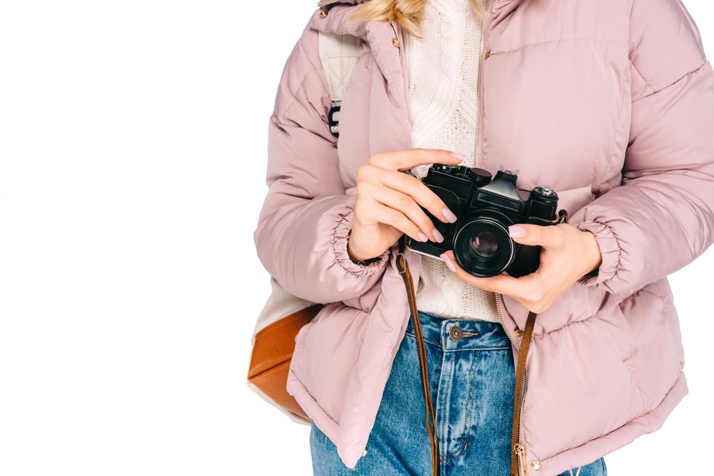 白で隔離のカメラを保持しているバックパックを持つ若い女性のクロップ撮影  - 写真・画像