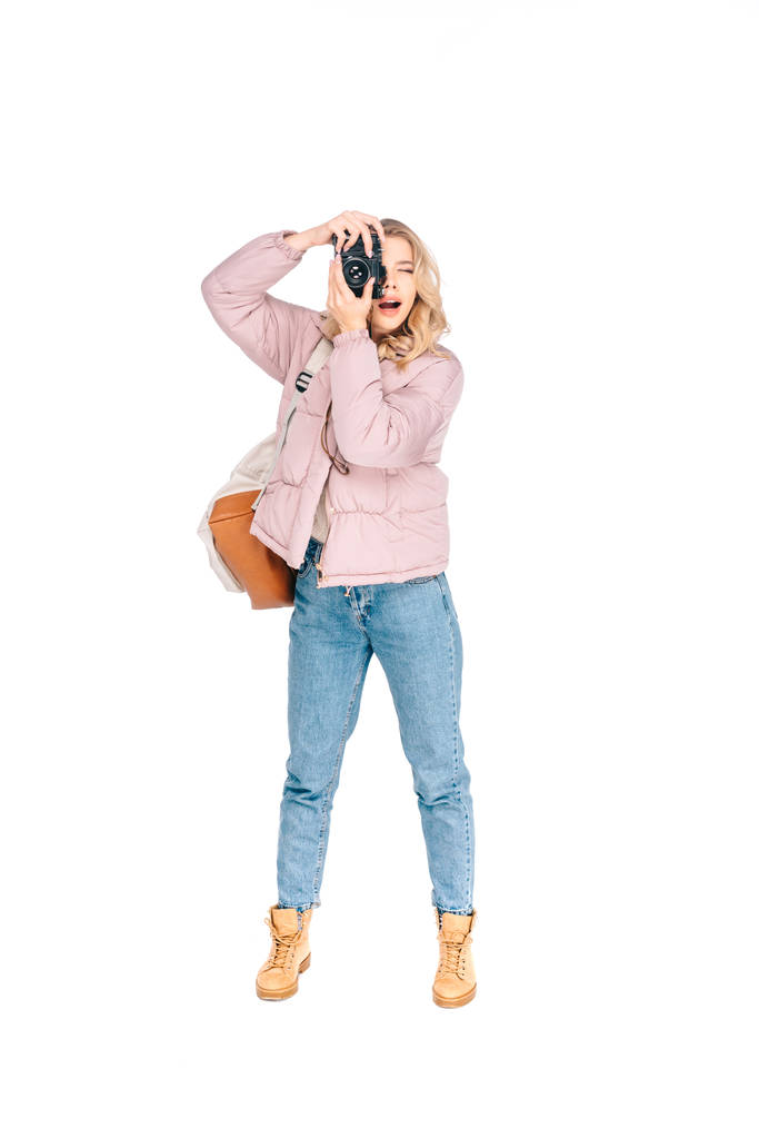 visão de comprimento total da jovem com mochila fotografando com câmera isolada em branco
 - Foto, Imagem