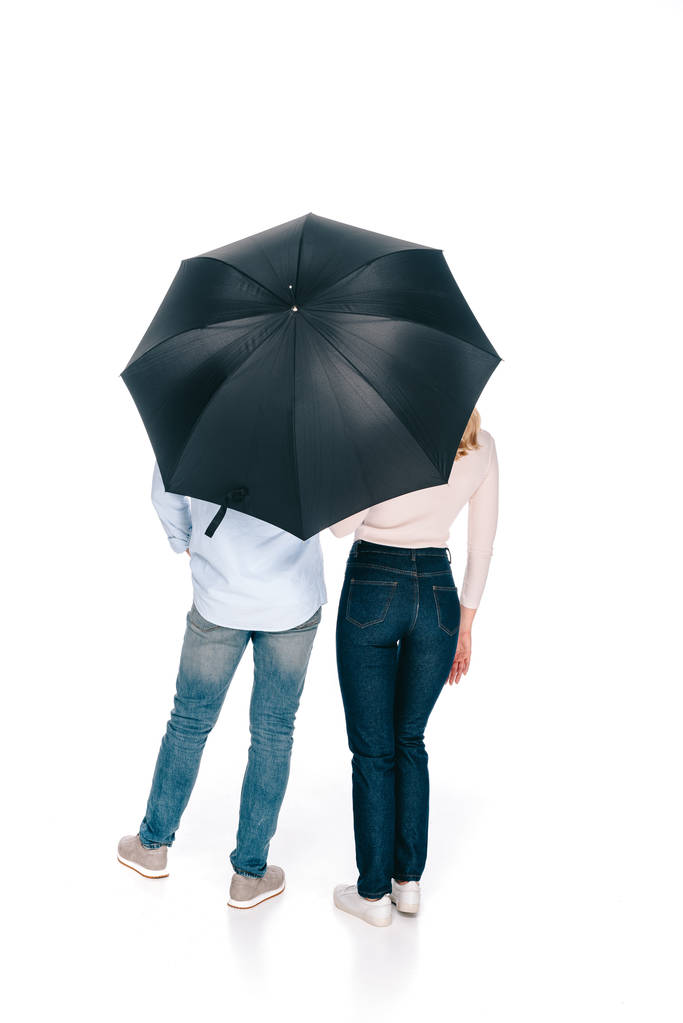 白で隔離の傘の下で若いカップル立っての背面図 - 写真・画像
