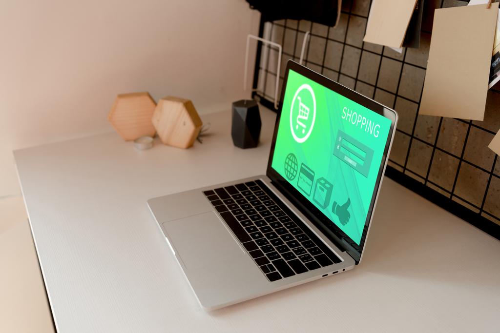 vista de cerca de la computadora portátil digital con letras de compras en la pantalla en la mesa en casa
 - Foto, imagen
