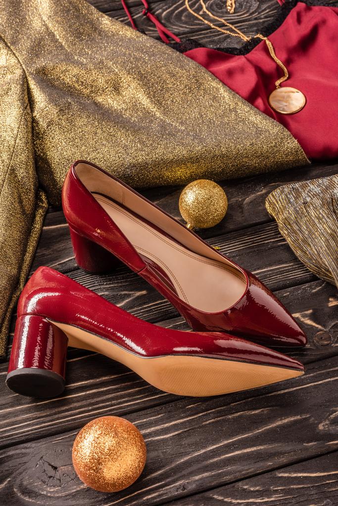 vue rapprochée de belles chaussures rouges féminines et de vêtements élégants sur une surface en bois
 - Photo, image