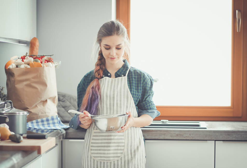 portrét mladé ženy stojící pozadí kuchyně. - Fotografie, Obrázek