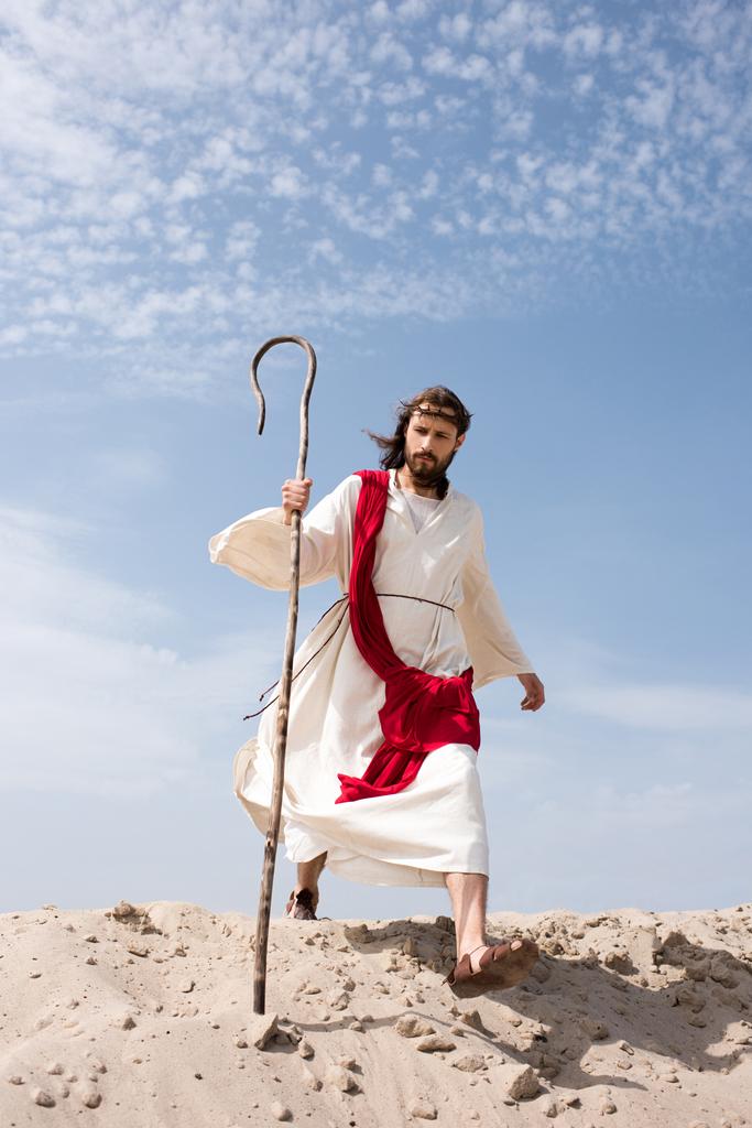 Jezus w szatę, czerwone skrzydła i Korona cierniowa, chodzenie na pustyni z personel - Zdjęcie, obraz