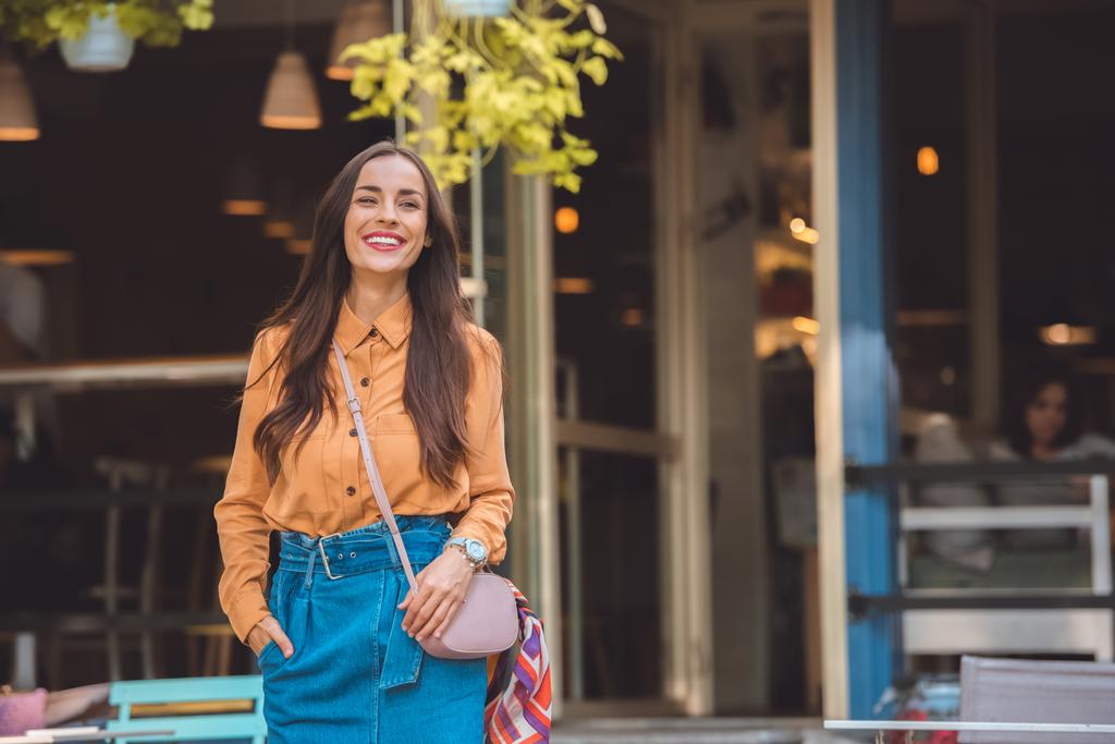 souriant jeune femme à la mode avec sac à main élégant à la rue urbaine
 - Photo, image