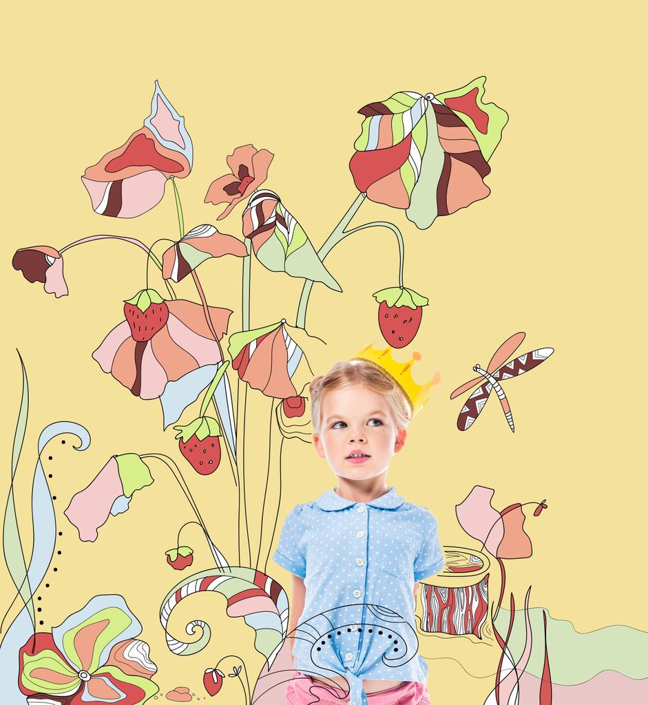 rozkošný zamyšlený kluk v papírové koruny, izolované na žluté s nakreslené jahody závod - Fotografie, Obrázek