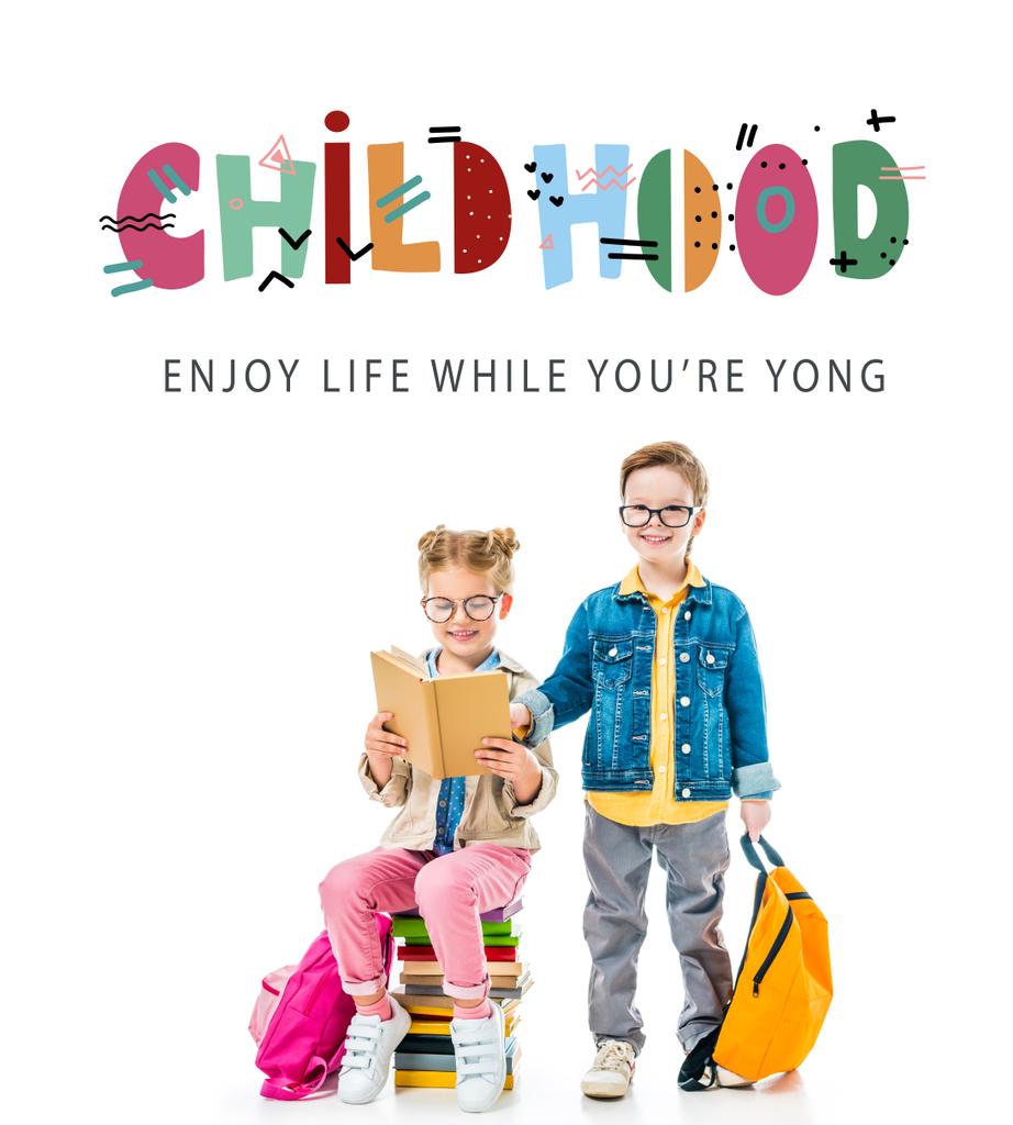 schoolchildren in eyeglasses studying and sitting on books with backpacks, isolated on white with "childhood - enjoy life while you are young" lettering - Photo, Image