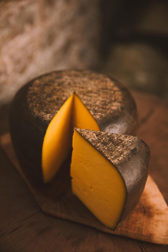 primo piano di formaggio tagliato a fette su tagliere in legno rustico
 - Foto, immagini