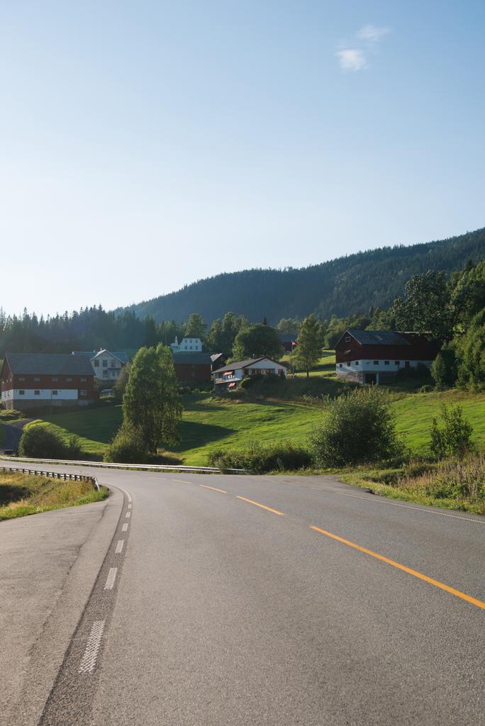 δρόμο που οδηγεί μέσα από το χωριό με τα σπίτια ζουν στο μεγαλύτερο χιονοδρομικό κέντρο της Trysil, Νορβηγία  - Φωτογραφία, εικόνα